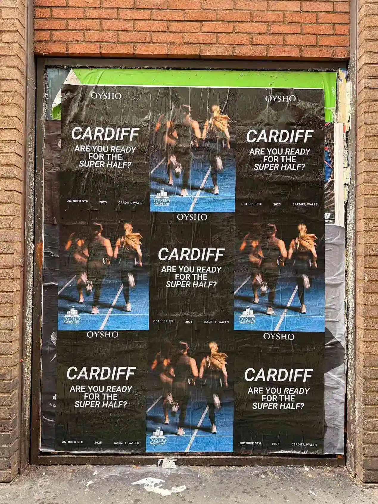 Classic poster advertising for Cardiff Super Half Marathon on building wall with multiple posters.
