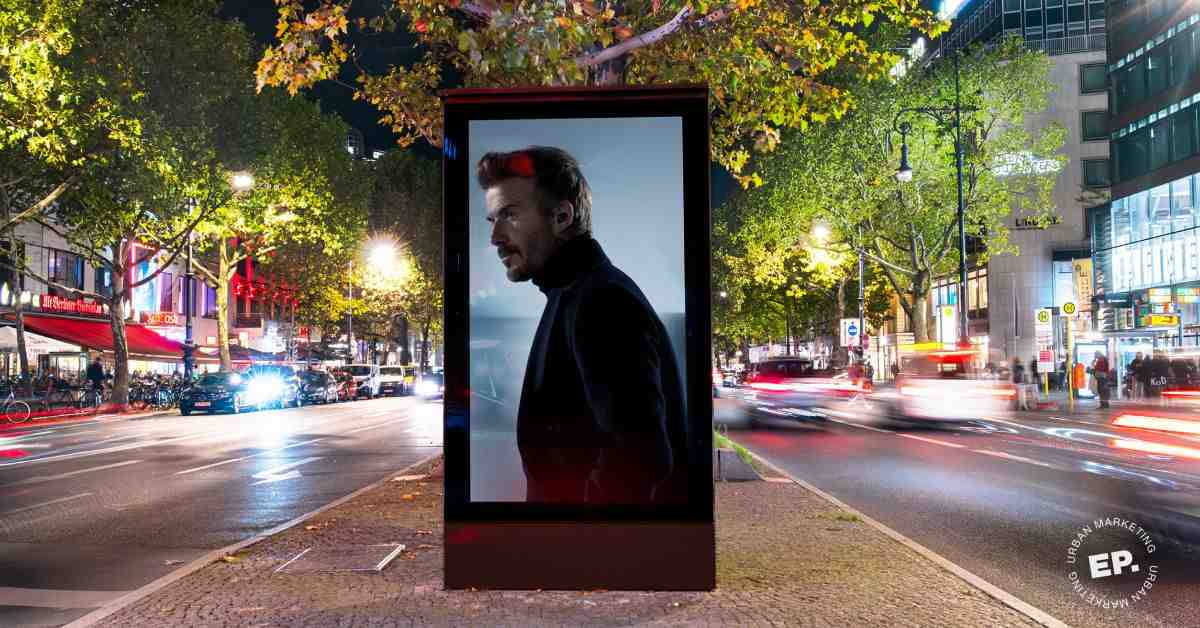Digitales City-Light-Poster (DCLP) mit Bowers-&-Wilkins-Motiv auf dem Mittelstreifen des Kurfürstendamms bei Nacht, Verkehr in Bewegungsunschärfe. Eigene Umsetzung von Echo Poster.
