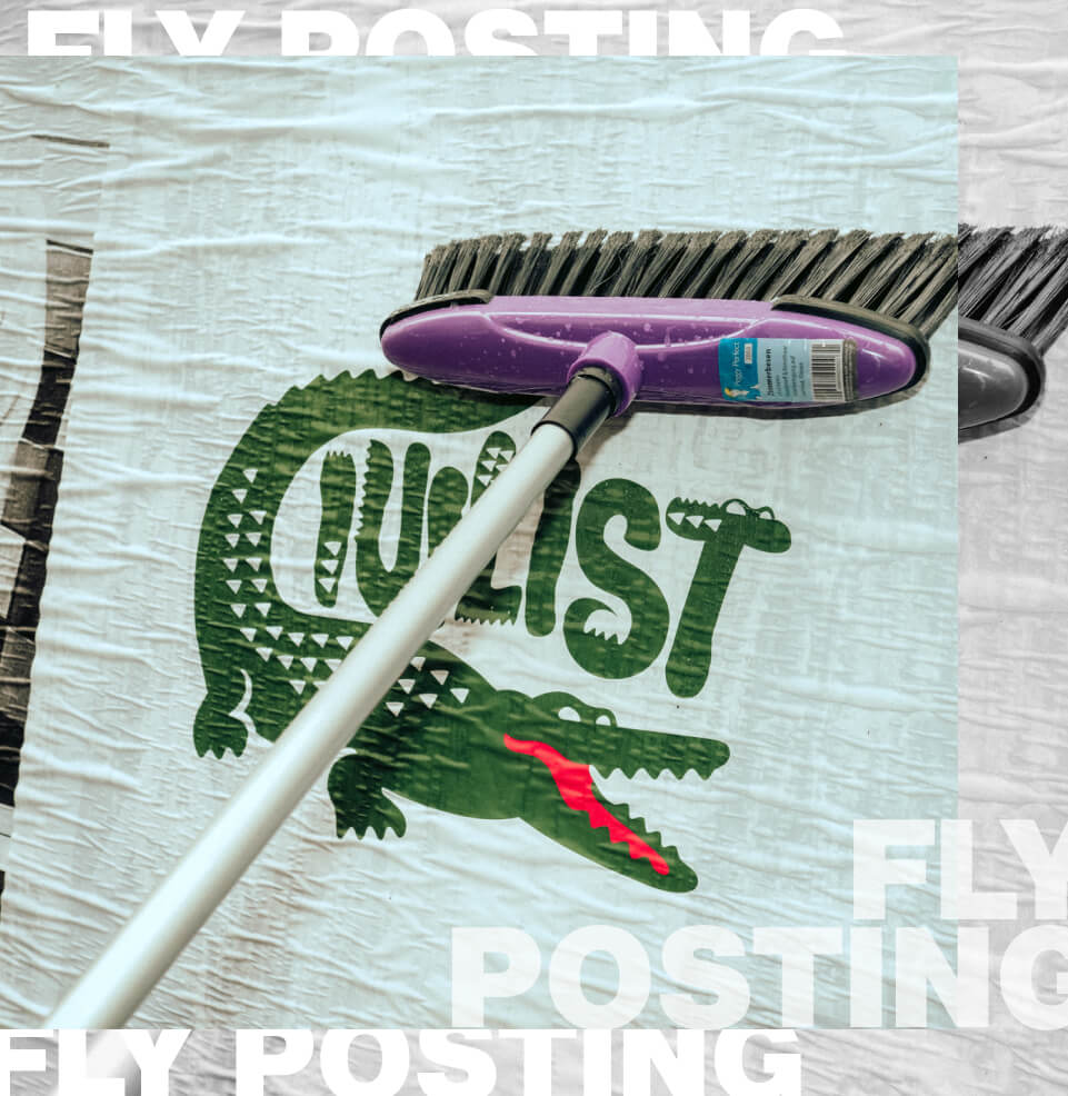 Nahaufnahme eines Plakats, das beim Flyposting mit einem Pinsel an eine Wand geklebt wird.