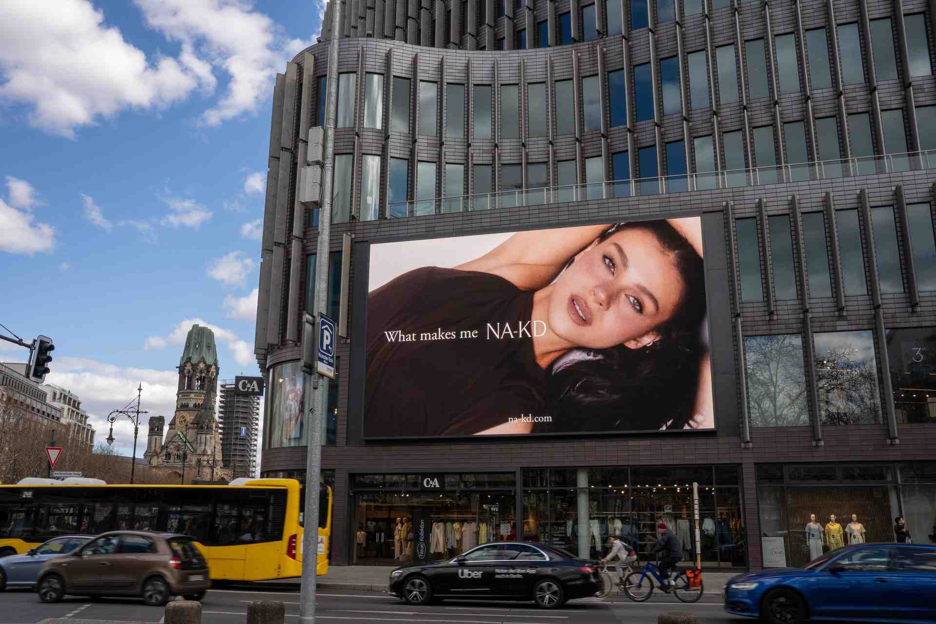 NA-KD Kampagne auf dem LED Prime Board am Kranzler Eck in Berlin, vor dem Büro und der Kirche